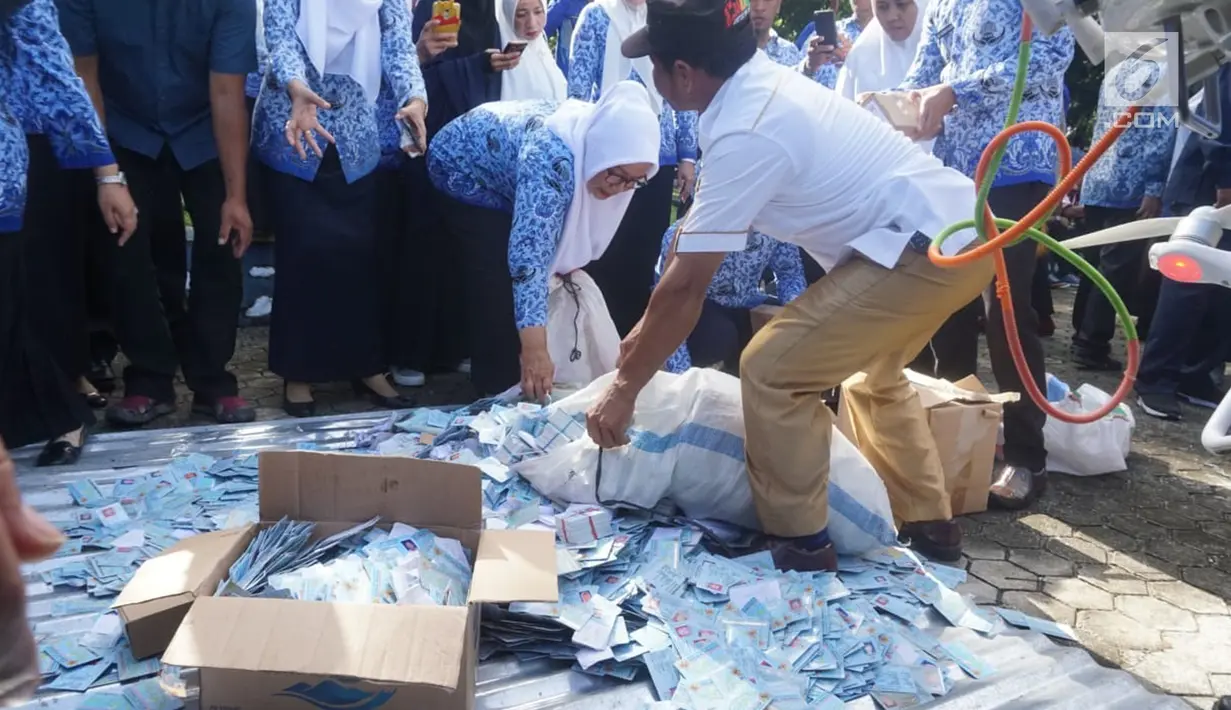 Petugas memusnahkan ribuan yang rusak di halaman Kantor Bupati Bone Bolango (Bonebol), Gorontalo, Selasa (18/12). Sebanyak 28.130 E-KTP rusak dimusnahkan Disdukcapil setempat untuk menghindari adanya penyalahgunaan. (Liputan6.com/Arfandi Ibrahim)