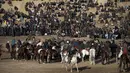 Para penunggang kuda Afghanistan bersaing memperebutkan bangkai saat pertandingan olahraga tradisional Buzkashi di Mazar-i-Sharif, Afghanistan (20/12). Buzkashi adalah olahraga tradisional yang cukup populer di kawasan Asia Tengah. (AFP/Farshad Usyan)