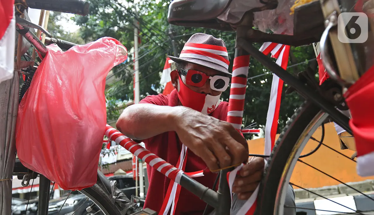 Pedagang jagung manis, Tarjono (52), memasang atribut merah putih pada sepedanya di kawasan Cilandak, Jakarta, Kamis (13/8/2020). Tarjono memodifikasi sepeda yang dipakainya untuk berjualan dengan atribut kemerdekaan dalam rangka memperingati HUT ke-75 RI. (Liputan6.com/Herman Zakharia)