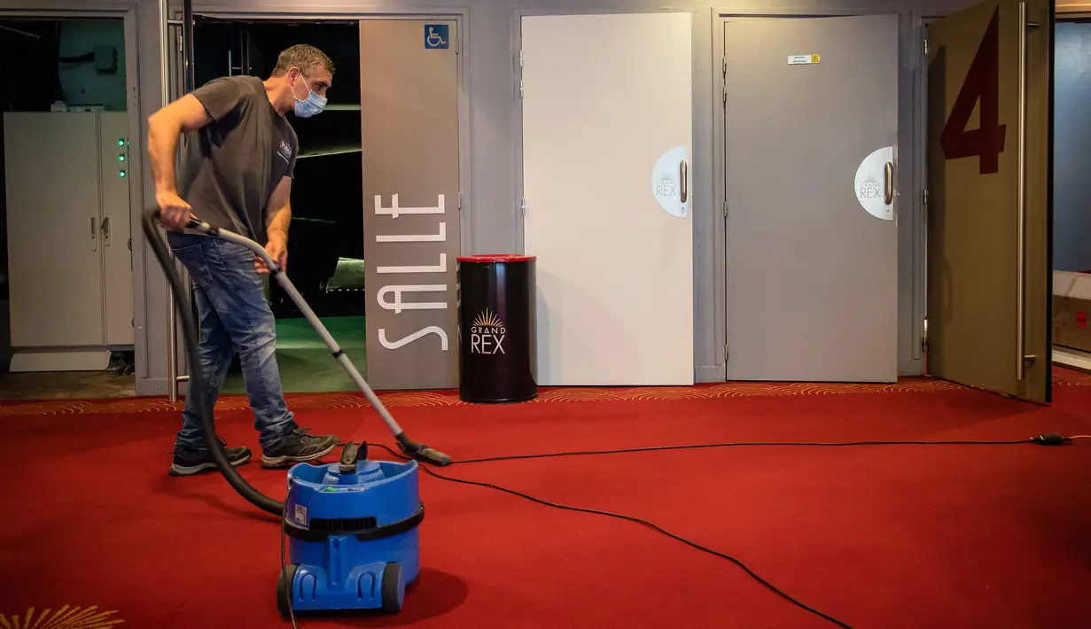 Pekerja menggunakan penyedot debu saat bersiap menyambut pembukaan kembali bioskop Le Grand Rex di Paris, Prancis (22/6/2020). Bioskop dan kasino kini kembali melanjutkan operasi dan kegiatan olahraga yang menarik tidak lebih dari 5.000 orang akan kembali diizinkan. (Xinhua/Aurelien Morissard)