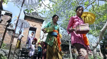 Wanita Bali melintas di dekat lokasi yang akan dikembangkan menjadi resor bintang enam yang dikelola oleh Trump Organization di Beraban, Bali, Rabu (12 /4). Trump berencana akan membangun sebuah Hotel megah yang menjulang ke Samudra Hindia. (AP Photo)