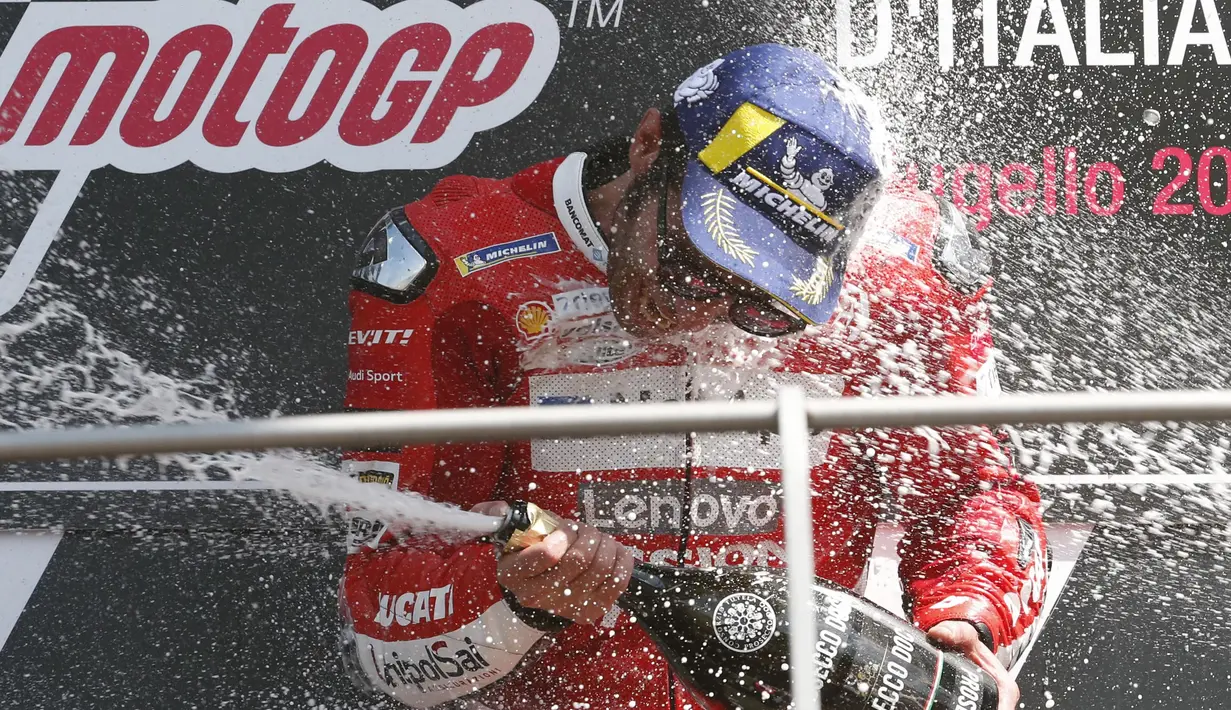 Pebalap Ducati, Danilo Petrucci, melakukan selebrasi usai menjuarai MotoGP Italia 2019 di Sirkuit Mugello, Minggu (2/6). Petrucci berhasil menuntaskan balapan 23 lap dengan catatan waktu 41 menit 33,794 detik. (AP/Antonio Calanni)