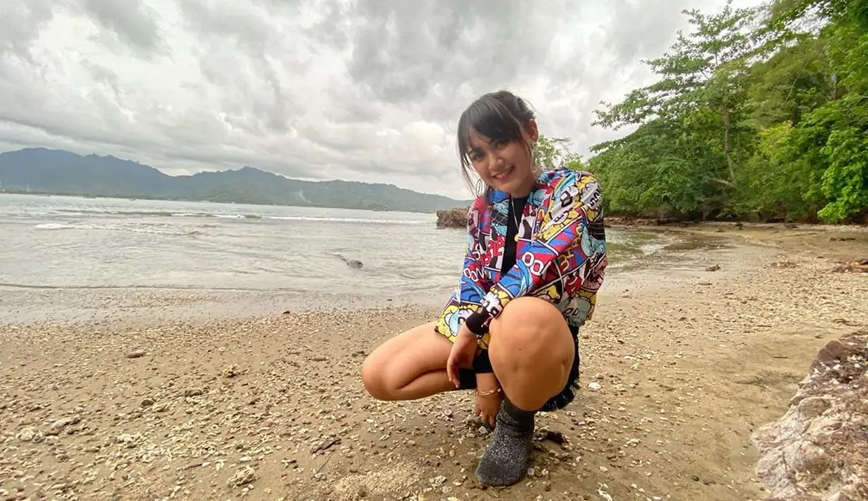 Pelantun lagu Sambel Terasi memang selalu tampil berwarna di setiap penampilannya. Saat berada di pantai Cengkrong Tulungagung, Happy terlihat sangat ceria dengan gaya OOTD yang kekinian. (Liputan6.com/IG/happy_asmara77)