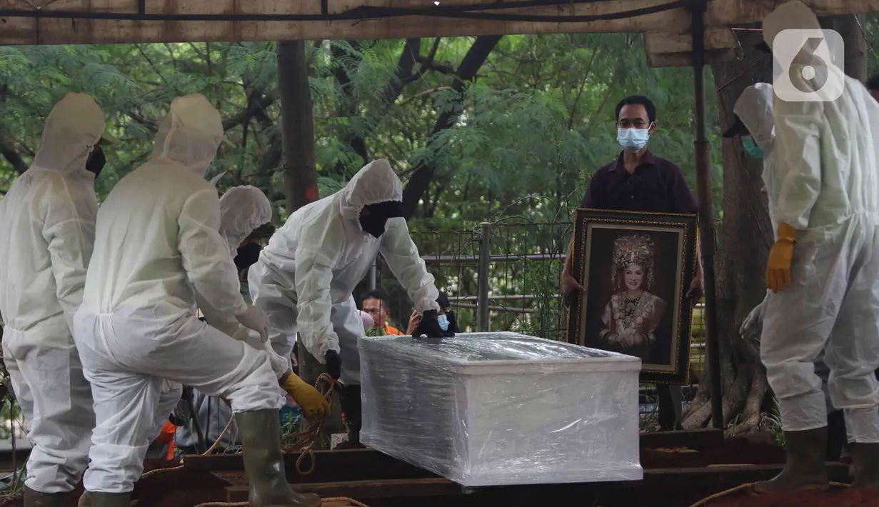 Petugas memakamkan jenazah Dedi Yuliardi Ashadi atau Dorce Gamalama di TPU Bantar Jati, Bambu Apus, Jakarta, Rabu  (16/2/2022). Ia berpulang setelah terpapar virus COVID-19. Dorce dimakamkan menggunakan protokol COVID-19 di TPU Bantar Jati, Bambu Apus. (Liputan6.com/Herman Zakharia)