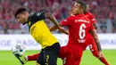 Gelandang Dortmund, Jadon Sancho, berebut bola dengan gelandang Bayern Munchen, Thiago Alcantara, pada laga Piala Super DFL di Stadion Signal Iduna, Dortmund, Sabtu (3/8). Dortmund menang 2-0 atas Munchen. (AFP/Ina Fassbender)