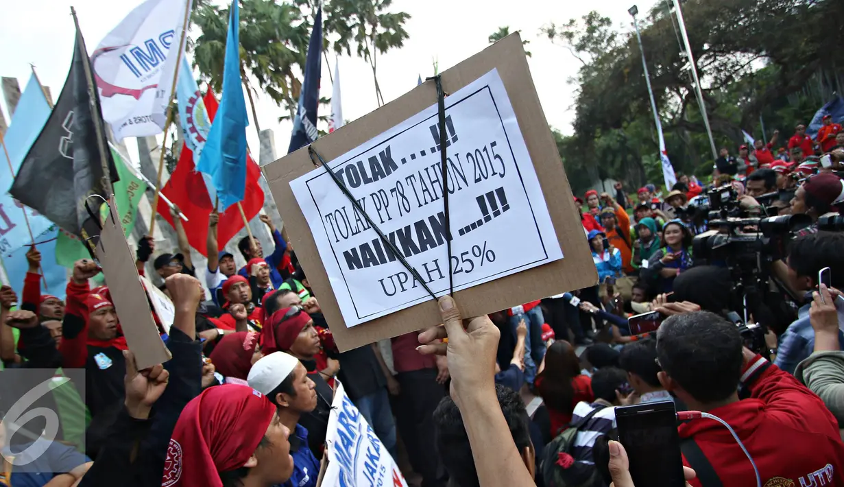 Buruh membawa spanduk saat berorasi di Tugu Proklamasi, Jakarta, Jumat (20/11). Dalam aksinya, para buruh menuntut pencabutan Peraturan Presiden (PP) No.78 Tahun 2015 tentang pengupahan, tolak formula upah minimum. (Liputan6.com/Immanuel Antonius)