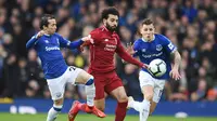 Aksi Mohamed Salah lewati dua pemain Everton pada laga lanjutan Premier League yang berlangsung di Stadion Goodison Park, Liverpool, Minggu (3/3). Liverpool imbang 0-0 kontra Everton. (AFP/Oli Scarff)