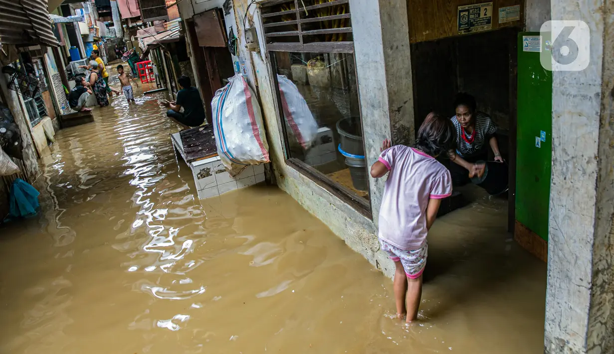 Warga membersihkan barang-barang yang terendam banjir di permukiman kawasan Kampung Melayu, Jakarta, Selasa (9/2/2021). Banjir yang berangsur surut dimanfaatkan warga untuk membersihkan rumah dan barang-barang dari endapan lumpur. (Liputan6.com/Faizal Fanani)