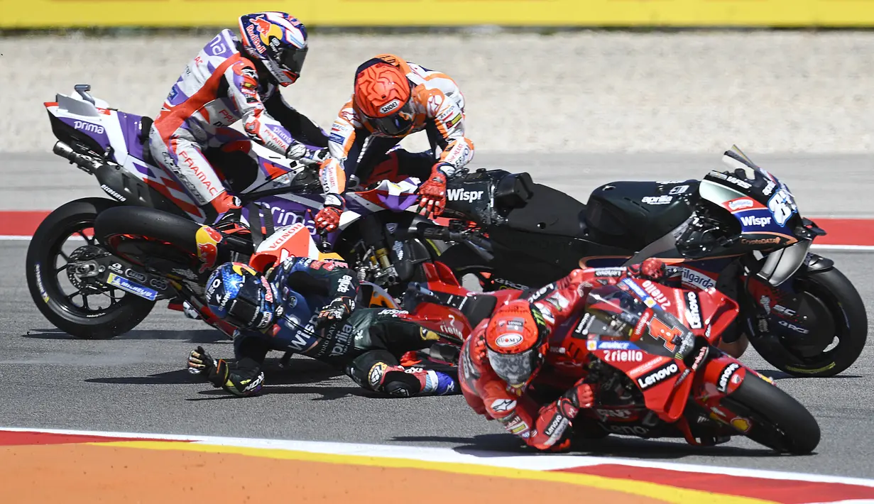 Pembalap Honda, Marc Marquez (atas), mengalami kecelakaan dengan pembalap Aprilia, Miguel Oliveira, dalam MotoGP Portugal 2023 yang berlangsung di Algarve International Circuit, Portimao, Minggu (26/3/2023). (AFP/Patricia De Melo Moreira)