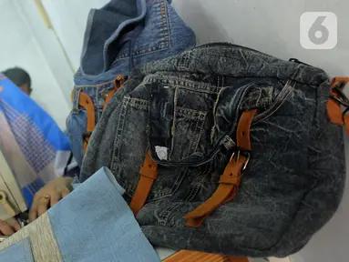 Perajin Risma Eljundi menyelesaikan pembuatan tas dari bahan celana jeans bekas di Legok, Tangerang, Banten, Senin (11/11/2019). Tas berbahan jeans itu dipasarkan ke kawasan Bandung serta pasar daring. (merdeka.com/Arie Basuki)