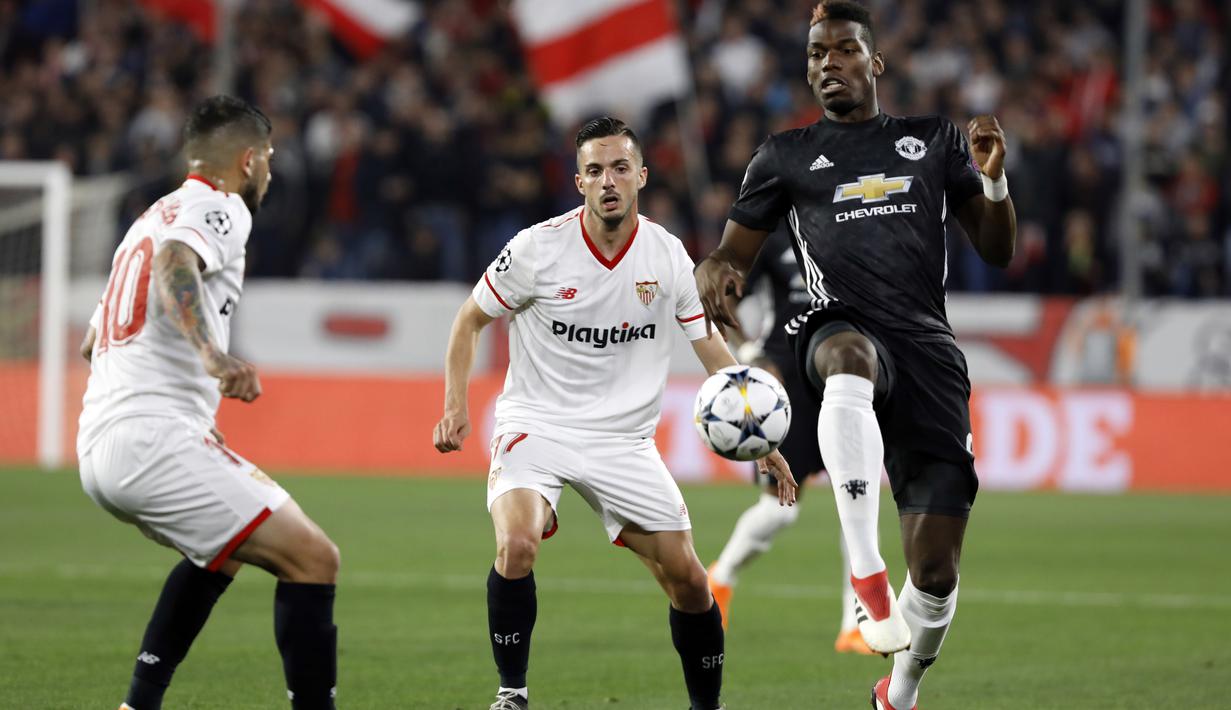 Pemain Manchester United, Paul Pogba (kanan) berusaha melewati adangan dua pemain Sevilla pada laga 16 besar Liga Champions di Ramon Sanchez Pizjuan stadium, Seville, (21/2/2018). Babak pertama berakhir imbang 0-0. (AP/Miguel Morenatti)