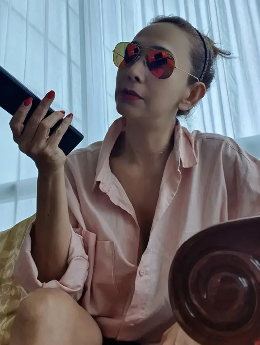 <p>Dengan kacamata hitamnya, Kiki mengenakan kemeja oversize pinknya. @qq_fatmala</p>