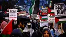 Para demonstran pro-Palestina melambaikan bendera Palestina dan memegang plakat saat berunjuk rasa di Parliament Square, London pada 21 Februari 2024. (HENRY NICHOLLS/AFP)