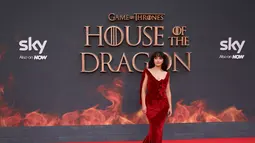 Olivia Cooke berpose di karpet merah saat tiba untuk menghadiri pemutaran perdana serial drama asli HBO "House of the Dragon" di Leicester Square Gardens, di London (15/8/2022). Olivia Cooke juga tampil memesona dengan memakai anting yang berkilau dengan gaun merahnya. (AFP/Hollie Adams)