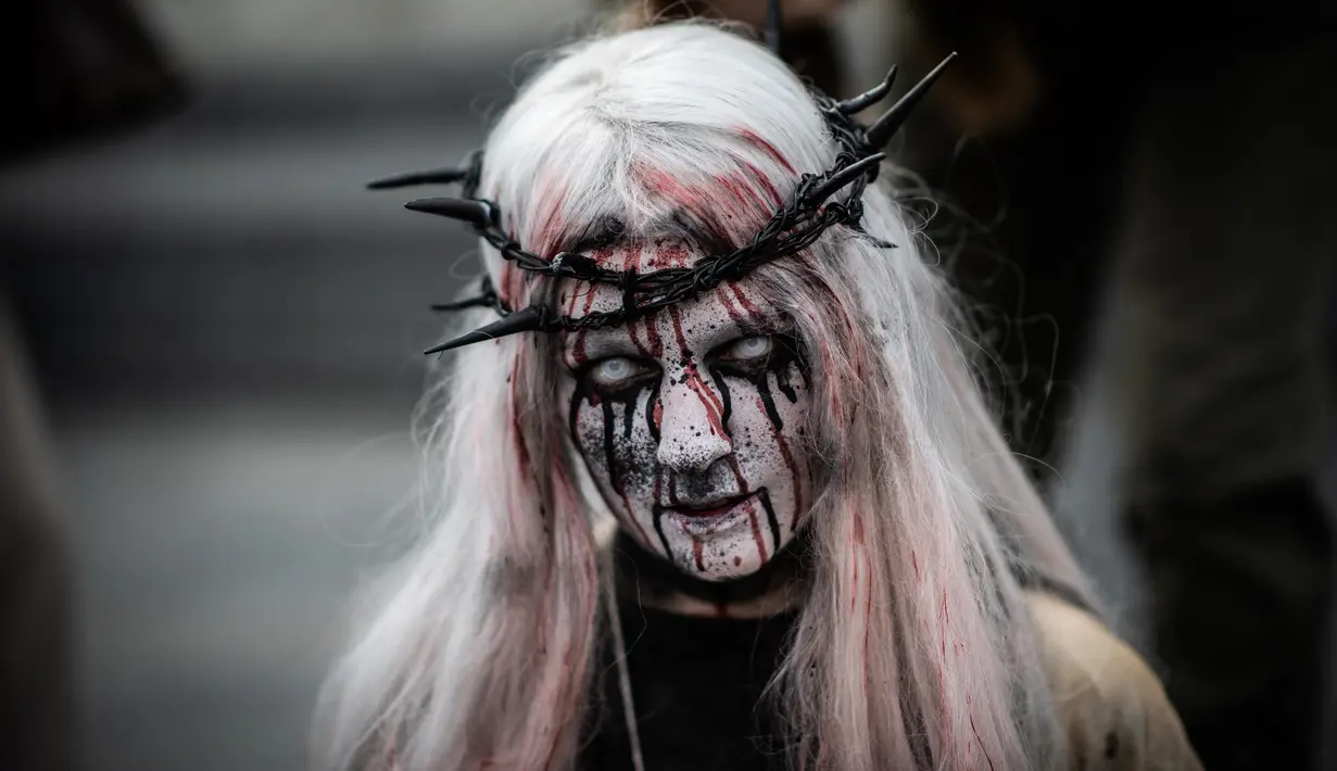 Penggemar film horor memakai kostum dan berdandan menyerupai zombie saat berpartisipasi dalam acara Zombie Walk di Place de la Republique, Paris, Sabtu (12/10/2019). Sejak 2008, acara Zombie Walk digelar untuk orang-orang yang terobsesi dengan mayat hidup. (Martin BUREAU / AFP)