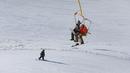 Pemain ski menuruni lereng saat dua orang lainnya duduk di kereta gantung resor ski Dizin, sebelah utara ibu kota Tehran, Iran, Kamis (8/3). Dizin merupakan salah satu yang resor ski es yang terletak di pegunungan Alborz Iran. (AP Photo/Vahid Salemi)