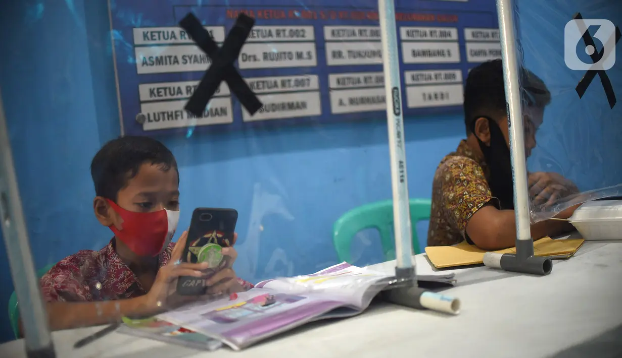 Sejumlah siswa mengikuti PJJ di Balai Warga RT 05/RW 02 Kelurahan Galur, Johar Baru, Jakarta, Selasa (15/8/2020). Program Internet Gratis untuk semua yang digalakan Pemprov DKI Jakarta ditujukan untuk mengatasi persoalan kesenjangan digital selama pandemi Covid-19. (Liputan6.com/Fery Pradolo)