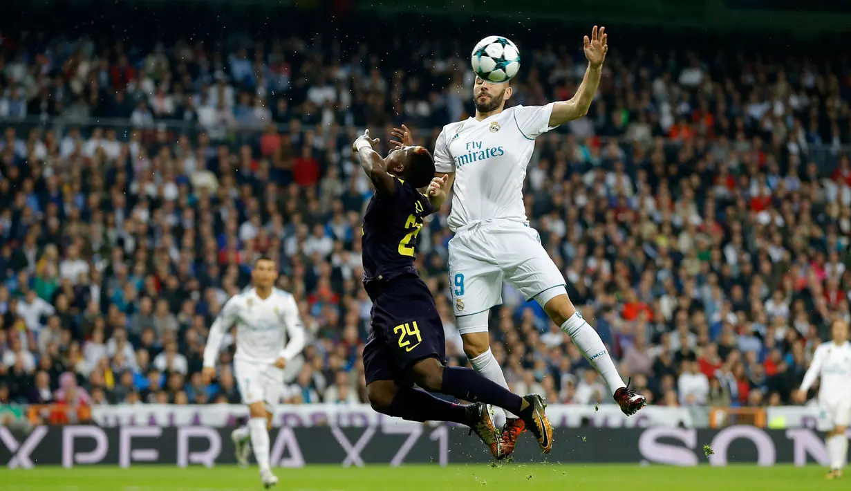 Pemain Real Madrid, Karim Benzema melompat untuk merebut bola dari pemain Tottenham Hotspur Serge Aurier pada laga lanjutan fase Grup H Liga Champions di Santiago Bernabeu, Selasa (17/10). Madrid ditahan imbang tamunya Tottenham 1-1.  (AP/Francisco Seco)