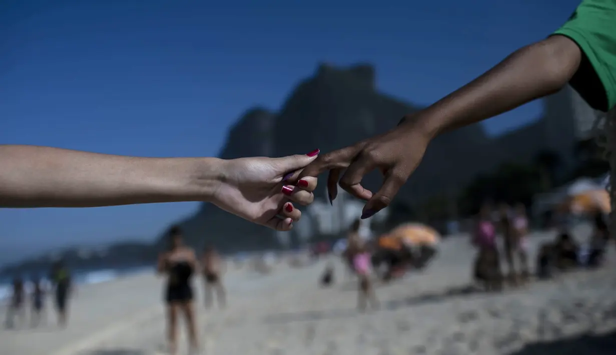 Selama acara berlangsung, para sukarelawan termasuk anak-anak memungut sampah dari pantai Sao Conrado. (AP Photo/Bruna Prado)
