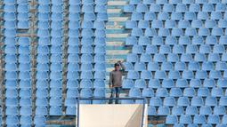 Seorang penonton berdiri sendirian dekat bangku kosong di tribun sebelum laga Persib Bandung melawan PS TNI pada lanjutan Liga 1 2017 di Stadion Si Jalak Harupat, Sabtu (05/8/2017). Persib menang 3-1. (Bola.com/Nicklas Hanoatubun)