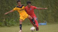 Gelandang Arema FC, Jayus Hariono, beradu dengan pemain Bintang Semeru FC dalam laga uji coba yang digelar di Lapangan Kusuma Agro Wisata, Kota Batu, Rabu (22/1/2020) pagi WIB. (Bola.com/Iwan Setiawan)
