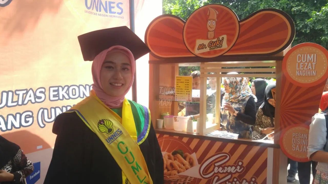 Usai wisuda, Ulfa nampang di depan salah satu outlet Cumi Krispy miliknya yang dibawa ke arena wisuda. (foto : Liputan6.com/edhie prayitno ige)