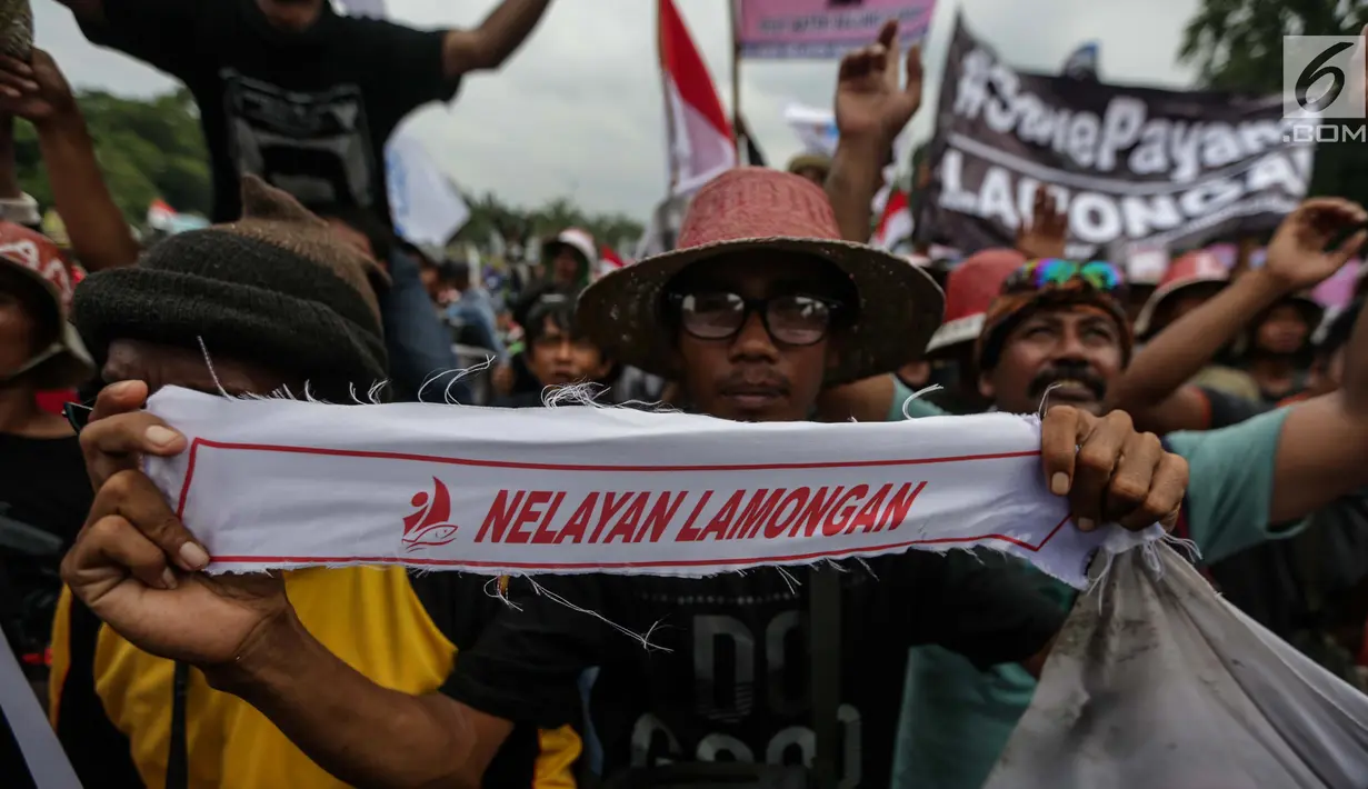 Nelayan membentangkan kain pengikat kepala dalam unjuk rasa menolak larangan penggunaan cantrang di depan Istana Negara, Jakarta Pusat, Rabu (17/1). Nelayan mendesak pencabutan Peraturan Menteri Nomor 2/2015 tentang cantrang. (Liputan6.com/Faizal Fanani)