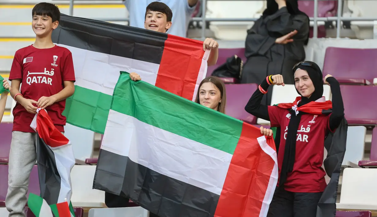 Suporter Uni Emirat Arab mengibarkan bendera jelang pertandingan sepak bola Grup C Piala Asia antara Hong Kong dan Uni Emirat Arab di Stadion Internasional Khalifa, Doha, Qatar, Minggu (14/1/2024). (AP Photo/Hussein Sayed)