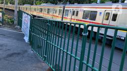 Kereta melintas di perlintasan sebidang dekat Stasiun Palmerah dan Gedung DPR/MPR yang ditutup permanen di Jakarta, Selasa (1/12/2020). Perlintasan ini tengah dilakukan kajian apakah di lokasi itu memungkinkan pembangunan flyover atau underpass. (Liputan6.com/Immanuel Antonius)