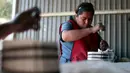 Seorang wanita mengisi bubuk mesiu untuk membuat petasan di Tultepec, Meskiko (22/12). Kota Tultepec ini memang dikenal sebagai lokasi utama pabrik pembuat petasan di Meksiko. (AFP/Pedro Pardo)