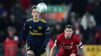 Gelandang Arsenal, Mesut Ozil berebut bola dengan gelandang Liverpool James Milner pada laga babak 16 Besar Carabao Cup di Anfield Stadium, Rabu (30/10/2019). Berimbang 5-5 di waktu normal, Liverpool menang 5-4 dalam adu penalti dan maju ke perempatfinal . (AP/Jon Super)