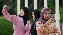 Umat Muslim berswafoto saat mereka berkumpul untuk sholat subuh untuk merayakan hari raya Idul Adha di Quirino Grandstand di Manila pada 28 Juni 2023. (AFP/JAM STA ROSA)