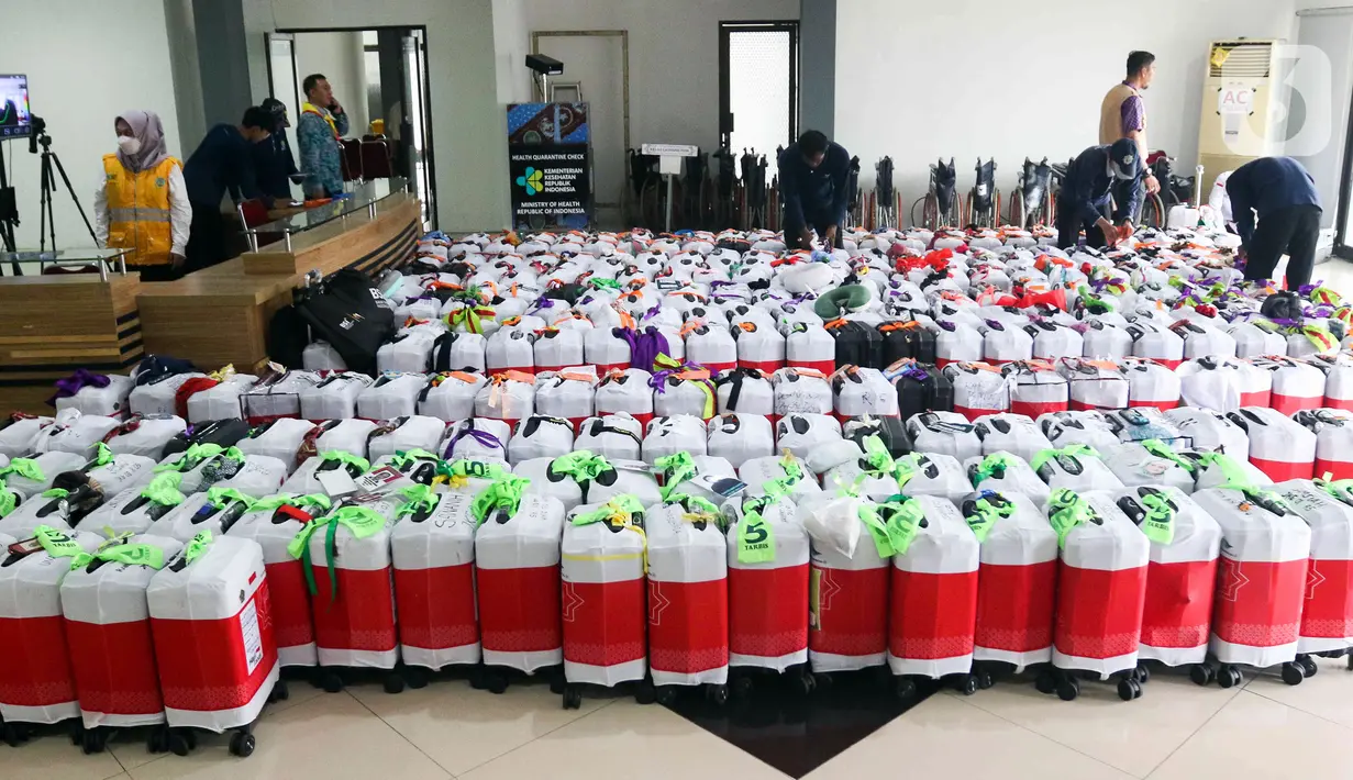 Petugas memeriksa koper bawaan calon jemaah haji di Asrama Haji Pondok Gede. (Liputan6.com/Herman Zakharia)