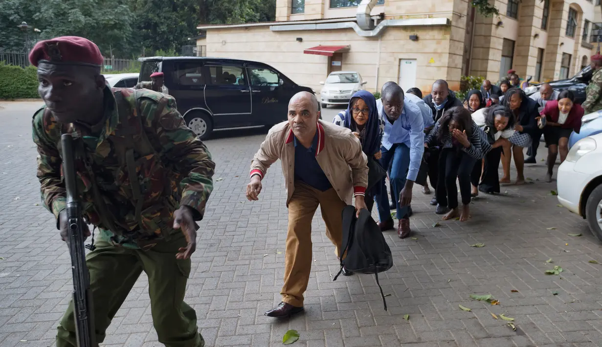 Pasukan keamanan mengawal warga melarikan diri saat terjadi serangan kelompok bersenjata ke sebuah kompleks hotel mewah di Nairobi, Kenya, Selasa (15/1). Serangan kelompok bersenjata tersebut dilakukan secara terkoordinasi. (AP Photo/Ben Curtis)