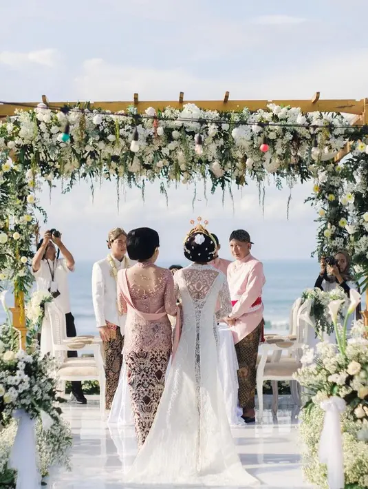 Sementara di bagian belakang, terlihat jelas keindahan ekor yang mengalir dari bagian punggung pengantin. Lengkap dengan sanggul klasik ala Jawa yang menambah kesakralan tampilan. [Foto: @rezaprabowophoto]
