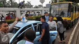 Pendemo melakukan sweeping terhadap taksi yang sedang melintasi jalan Gatot Subroto  saat demo di depan Gedung DPR/MPR, Jakarta, Selasa (22/3). Mereka menuntut pemerintah untuk membekukan jasa transportasi berbasis online. (Liputan6.com/Johan Tallo)
