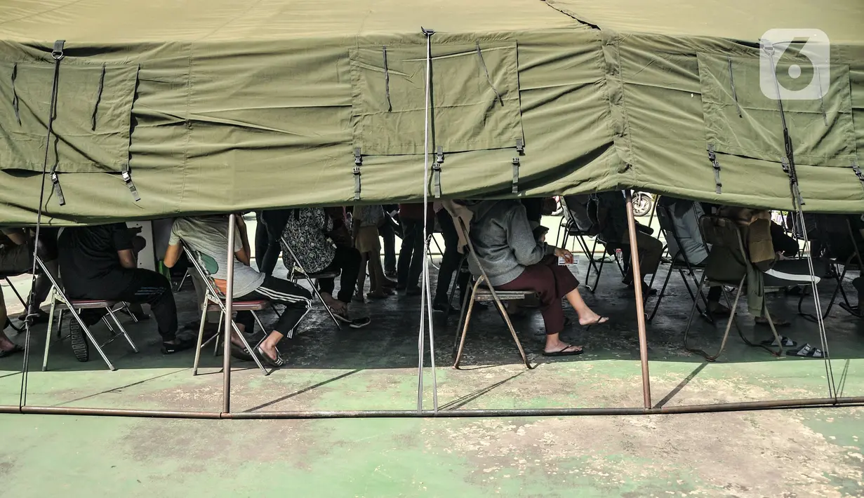 Warga menunggu dalam tenda saat program Vaksinasi Keliling di RPTRA Pulo Besar, Sunter Jaya, Jakarta, Senin (12/7/2021). Pemprov DKI menggelar Vaksinasi Keliling dengan sistem jemput bola guna mempermudah pelayanan kepada masyarakat di area padat penduduk. (merdeka.com/Iqbal S Nugroho)