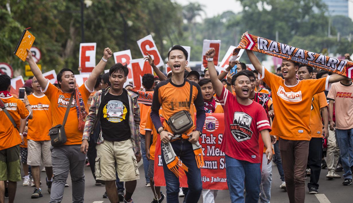 Suporter Persija Jakarta, The Jakmania, bernyanyi saat akan menonton laga Liga 1 melawan Mitra Kukar di Senayan, Jakarta, Minggu (9/12). Persija berpeluang besar menjadi juara jika berhasil menang. (Bola.com/Vitalis Yogi Trisna)
