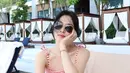 <p>Detail pita pada tali bahunya mempercantik kesan femininnya, sementara memadukannya dengan topi bisbol dan kacamata hitam bundar menciptakan tampilan yang stylish. (Foto: Instagram/ kyo1122)</p>