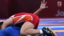 Pegulat putra Indonesia, Muhammad Aliansyah saat bertarung melawan pegulat Korea Utara Kim Myong Chol pada kelas putra 67 Kg di arena gulat JCC Senayan, Selasa (21/8). (Liputan6.com/Fery Pradolo)