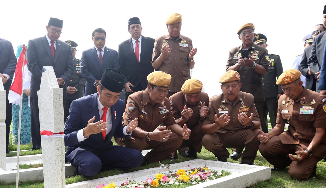 Presiden Joko Widodo bersama para veteran berdoa usai menabur bunga di TMP Cikutra, Bandung, Sabtu (10/11). Jokowi menabur bunga di atas makam sejumlah Pahlawan Nasional. (Liputan6.com/Angga Yuniar)