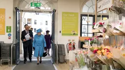 Ratu Inggris Elizabeth II bersama rombongan didampingi Direktur pasar swalayan Waitrose, Rupert Thomas saat tiba di pasar swalayan Waitrose pada kunjungannya di Kota Poundbury, Inggris (27/10). (Reuters/Justin Tallis)