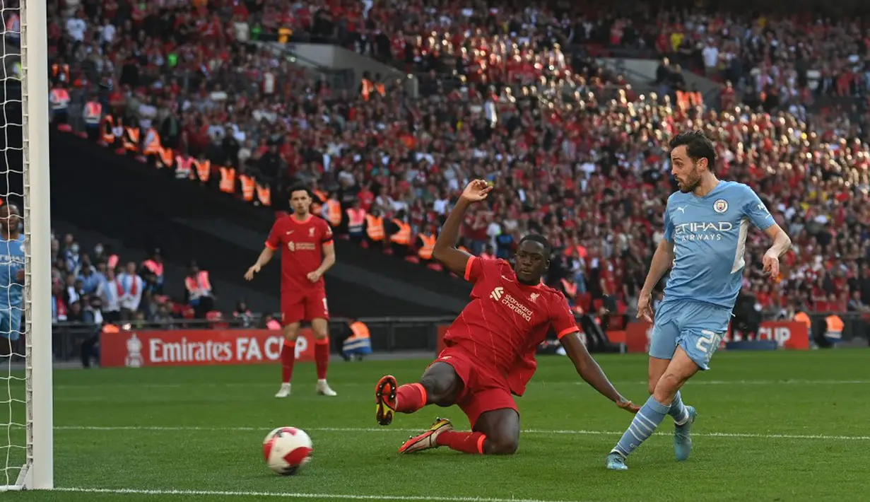 Pemain Manchester City Bernardo Silva (kanan) mencetak gol ke gawang Liverpool pada pertandingan sepak bola semifinal Piala FA di Stadion Wembley, London, Inggris, 16 April 2022. Liverpool menang 3-2. (Glyn KIRK/AFP)