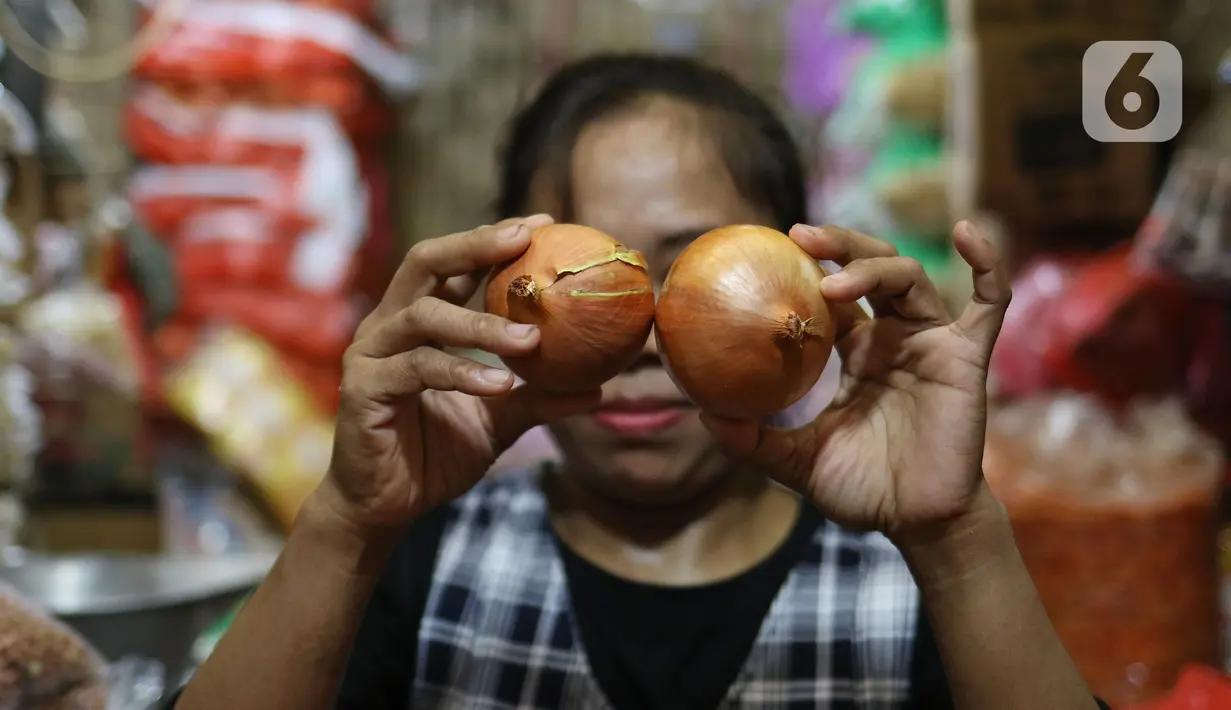 Pedagang memperlihatkan bawang bombay dagangannya di dPasar Induk Kramat Jati, Jakarta, Kamis (12/3/2020). Para pedagang di pasar tradisional, mengeluhkan harga bawang bombay yang melonjak drastis hingga 10 kali lipat dari harga normal. (Liputan6.com/Herman Zakharia)