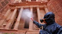 Petugas menyemprotkan cairan disinfektan di kota arkeologi Petra, Yordania, 17 Maret 2020. Berdasarkan data terbaru Universitas Johns Hopkins pada 21 Maret 2020, jumlah kasus virus corona COVID-19 di Yordania mencapai 85 orang. (Photo by Khalil MAZRAAWI/AFP)
