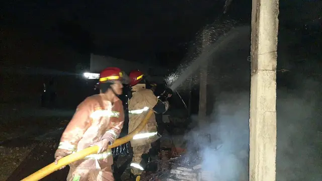 Damkar berupaya memadamkan api di rumah milik SY (58 th), di Desa Adikarto, Adimulyo, Kebumen, yang diduga dibakar sendiri. (Liputan6.com/Polres Kebumen/Muhamad Ridlo)