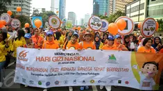 Suasana peserta saar membawa spanduk dalam aksi peringati Hari Gizi Nasional di kawasan Bunderan HI, Jakarta, Minggu (31/2/2015). Dalam aksinya memberikan memberitahukan pentingnya sayur mayur diberikan untuk anak. (Liputa6.com/Faizal Fanani)