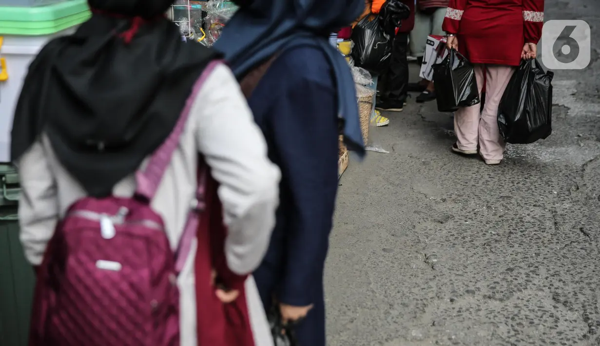 Warga membawa barang belanjaan dengan menggunakan kantong plastik di Kawasan Pasar Jatinegara, Jakarta, Selasa (30/6/2020). Mulai 1 Juli 2020 penggunaan kantong plastik sekali pakai dilarang di mal, toko swalayan, dan pasar tradisional di DKI Jakarta. (Liputan6.com/Faizal Fanani)