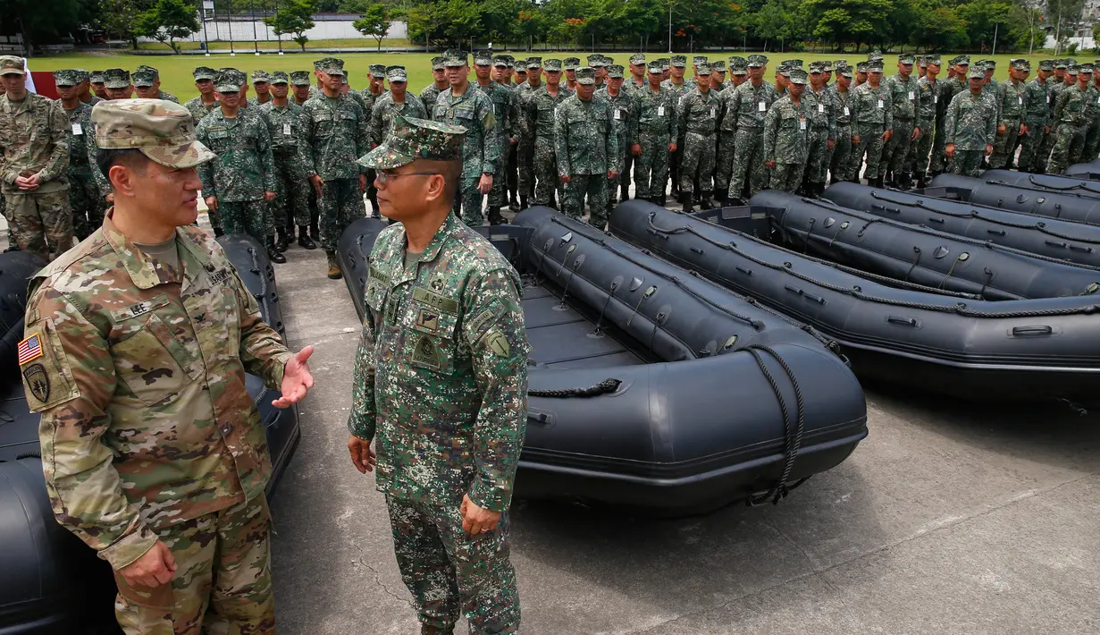 Kolonel Ernest Lee berbincang dengan Mayjen Marinir Filipina Emmanuel Salamat saat serah terima senjata baru yang diberikan AS ke Filipina di kota Taguig, sebelah timur Manila, Filipina (5/6). (AP Photo / Bullit Marquez)