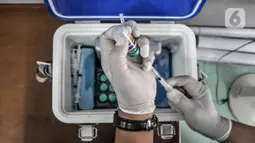 Tim paramedis Suku Dinas Ketahanan Pangan, Kelautan, dan Pertanian Jakarta Timur menyiapkan vaksin rabies untuk disuntikkan kepada hewan peliharaan warga di Kantor RW 07 Cipinang Muara, Jatinegara, Jakarta, Senin (6/9/2021).  Vaksinasi keliling ini digelar di tiap RW. (merdeka.com/Iqbal S. Nugroho)
